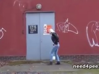 Başlangyç adolescent hides behind a wall to take a pee